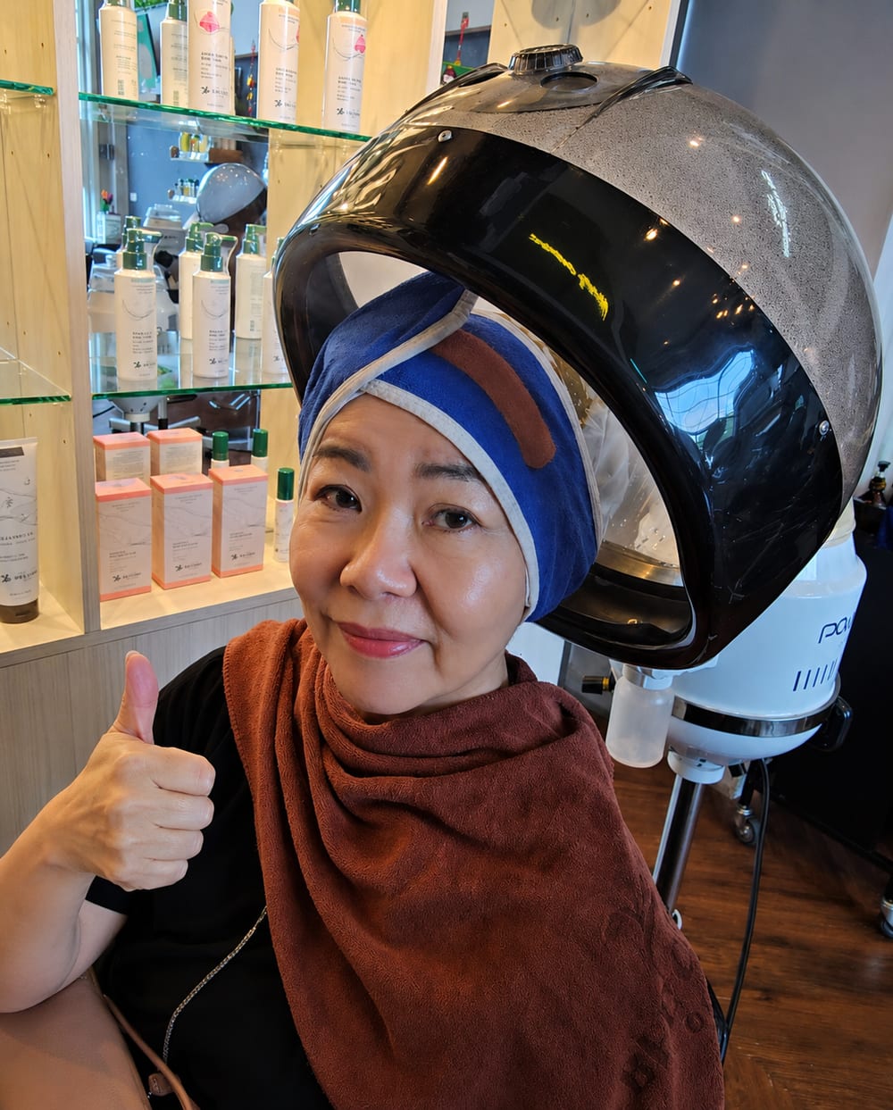Bee Choo Ladies client giving thumbs up during herbal scalp treatment